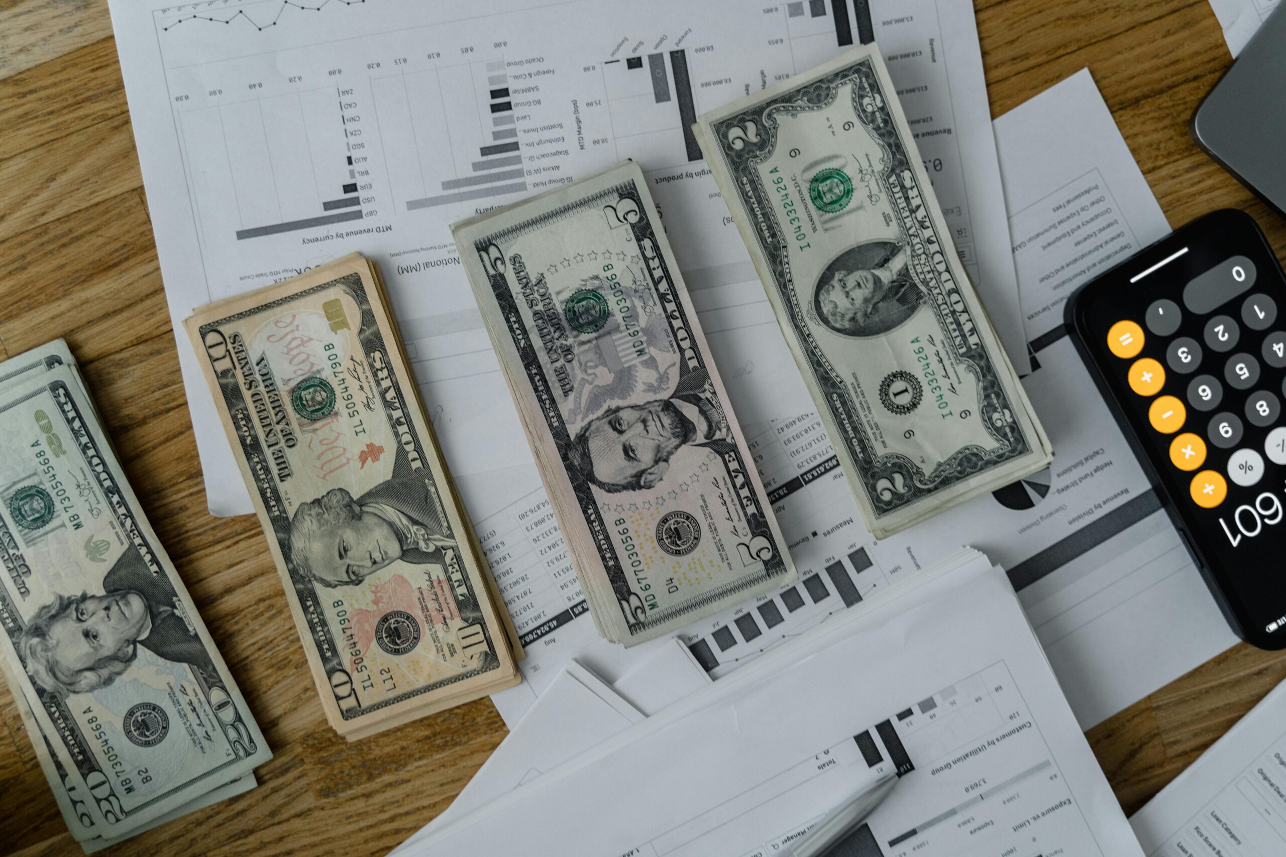 USD Currency in different denominations as well as worksheets and a calculator.